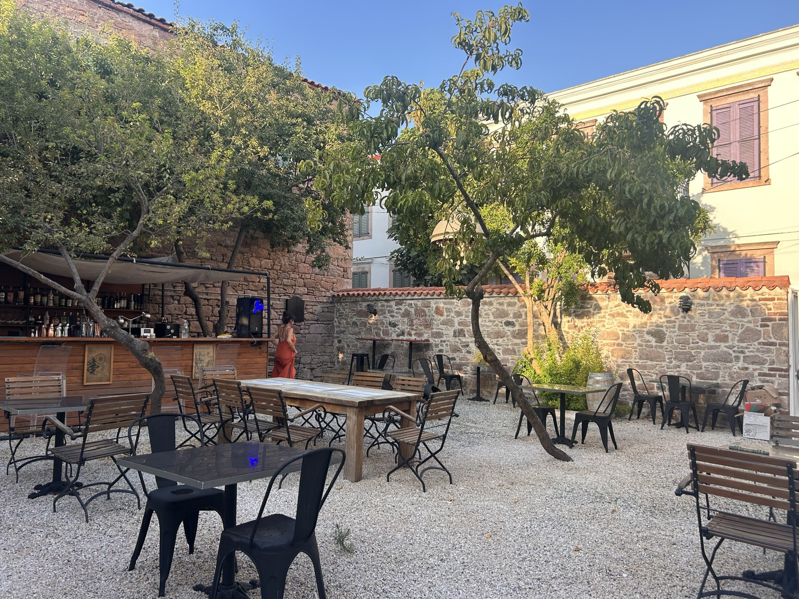 Sakin Bar — taş avluda ahşap bar, Cunda